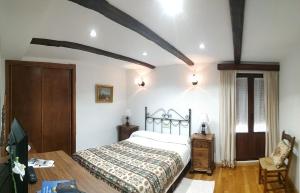 1 dormitorio con 1 cama y suelo de madera en Hostal Rio Almar, en El Cabaco