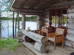 PätiäläにあるHoliday Home Mäkitorppa by Interhomeの木製のテーブルと椅子が備わるログキャビンのポーチ