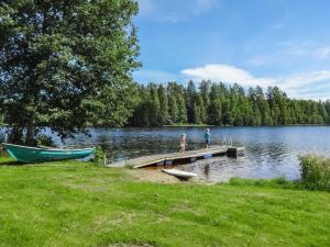 a couple of people standing on a dock next to a lake at Holiday Home Villa elisabet by Interhome in Löytö +18 photos