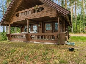 une grande cabane en bois avec une terrasse couverte dans les bois dans l'établissement Holiday Home Auringonlasku by Interhome, à Hirvikoski