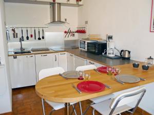 uma cozinha com uma mesa de madeira com pratos e copos de vinho em Apartment L'Ile heureuse-6 by Interhome em Saint-Cyr-sur-Mer