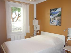um quarto com uma cama branca e uma janela em Apartment L'Ile heureuse-6 by Interhome em Saint-Cyr-sur-Mer