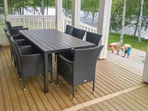 una mesa negra y sillas en un porche con un niño en Holiday Home Villa elisabet by Interhome, en Löytö