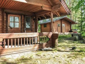 une cabane en rondins avec une véranda et une clôture dans l'établissement Holiday Home Auringonlasku by Interhome, à Hirvikoski