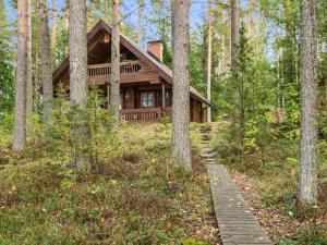 une cabane en rondins dans les bois avec un chemin menant à celle-ci dans l'établissement Holiday Home Auringonlasku by Interhome, à Hirvikoski 18 autres photos
