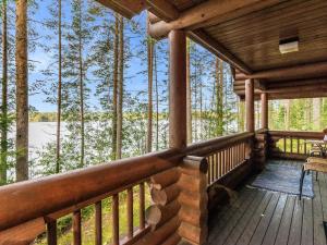 a porch of a log cabin with a view of a lake at Holiday Home Iltarusko by Interhome in Vuoriniemi