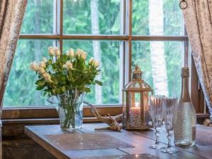 a table with a vase of flowers and a window at Holiday Home Mäkitorppa by Interhome in Pätiälä
