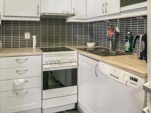 a kitchen with white cabinets and a sink at Holiday Home Vuokatinportti b 9 by Interhome in Lahdenperä
