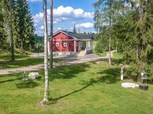 una casa roja en medio de un patio en Holiday Home Villa urho by Interhome en Löytö