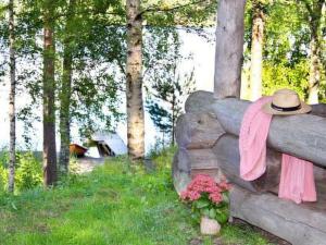 a hat and a pink scarf on a fence with flowers at Holiday Home Mäkitorppa by Interhome in Pätiälä