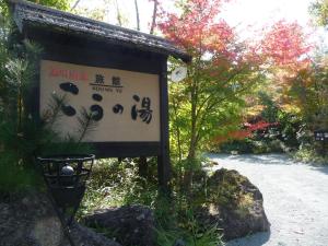 a sign for a garden with trees and a path at Ryokan Kono-Yu in Minamioguni