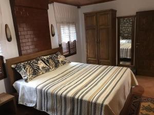 een slaapkamer met een groot bed en een gestreepte deken bij Guesthouse Arjan in Berat