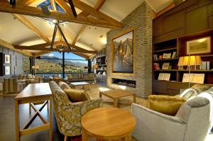 a living room filled with furniture and a large window at The Rees Hotel & Luxury Apartments in Queenstown