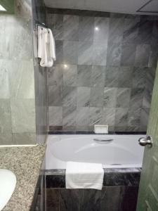 uma casa de banho com uma banheira, um WC e um lavatório. em LEE PLACE HOTEL em Banguecoque