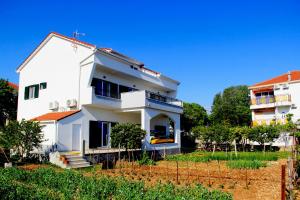 een wit huis bovenop een veld bij Apartment Luce in Trogir