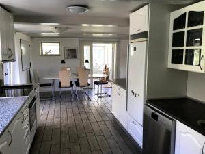 a kitchen with white cabinets and a table with chairs at Tingvej 15 Feriehus in Aabenraa
