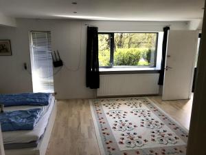 a bedroom with a bed and a window and a rug at Tingvej 15 Feriehus in Aabenraa
