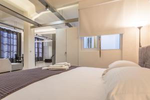 1 dormitorio con 1 cama blanca grande y sala de estar en Renovated Loft At the Center of Monastiraki en Athens