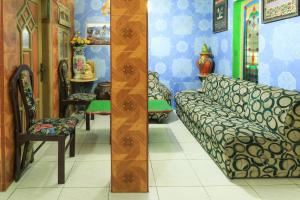 Zimmer mit Sofa und Stühlen in der Unterkunft Dharmawati Homestay Syariah at Terminal Purabaya in Waru