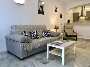 Apartamentos Las Rosas de Capistrano في نيرخا: غرفة معيشة مع أريكة وطاولة