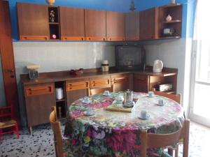 a kitchen with a table with a floral table cloth at Luna Rossa da Nadia in Levanto