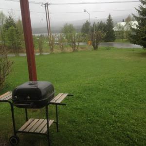 a grill sitting on a bench in a yard at Funäs Fjäll Lägenhet in Funäsdalen