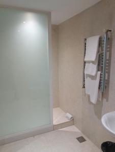 a bathroom with a shower and a sink and towels at Hotel Fabrik in Humanes de Madrid