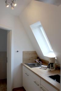 a kitchen with a sink and a skylight at Villa Waldheim - WG 2 in Boltenhagen