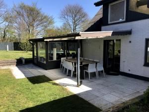 a pavilion with a table and chairs on a patio at Tingvej 15 Feriehus in Aabenraa