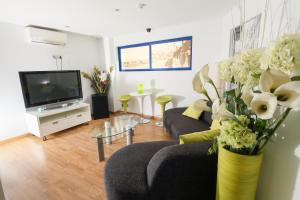 a living room with a couch and a tv at Hotel Fetiche Alojamiento con Encanto in Benidorm