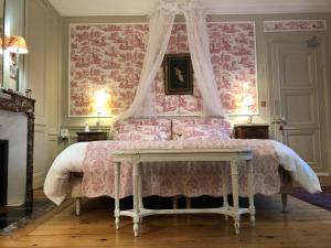 - une chambre avec un lit rose à baldaquin dans l'établissement VILLA la GLORIETTE, à Rouen