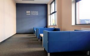 a row of blue chairs in a room with a wall at Apartament SURF SurfingBird Kołobrzeg in Kołobrzeg