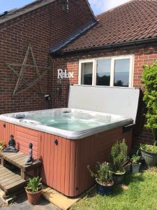 a hot tub in the backyard of a house at The Paddock at Peacock Farm near Belvoir Castle in Redmile