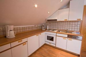 a kitchen with white cabinets and a counter top at Haus Panorama Sankt Andreasberg in Sankt Andreasberg