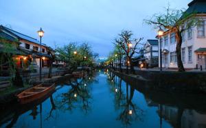 un canal en una ciudad por la noche con luces de la calle en Temari Inn Oitoma en Kurashiki