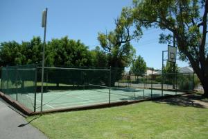 a tennis court with two tennis courts at Acclaim Kingsway Tourist Park in Perth