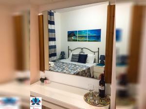 riflessione di una camera da letto con un letto in uno specchio di Appartamenti Monacò a San Vito lo Capo
