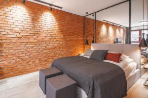 een slaapkamer met een bed en een bakstenen muur bij CITYSTAY Waterlane Island Apartment in Gdańsk