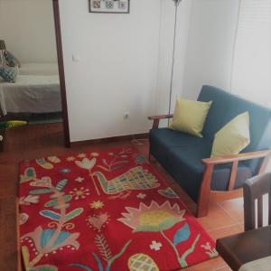 a living room with a blue couch and a red rug at Apartamento 2 - Fundação de Veiros in Veiros