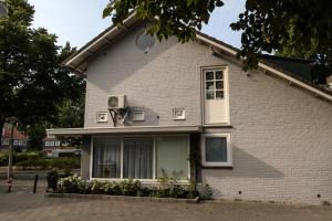 ein weißes Backsteinhaus mit einem Fenster in der Unterkunft B&B Amsterdam De Springer in Amsterdam