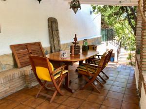einen Holztisch und Stühle auf einer Terrasse in der Unterkunft Villa Pinares-Malaga: pool, garden, garaje, wifi, in Málaga