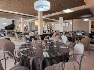 un salón de banquetes con mesas y sillas con gafas. en Hostal Nobadis, en Cervera