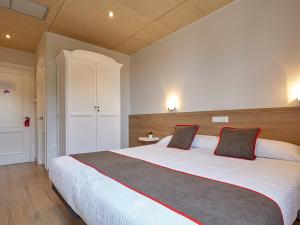 Un dormitorio con una gran cama blanca con dos almohadas. en Hostal Nobadis, en Cervera