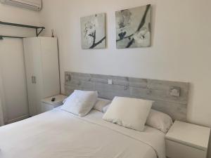 a bedroom with a white bed with two pillows at Hostal Eixample in Barcelona