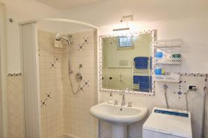 ein Badezimmer mit Waschbecken und Dusche mit Spiegel in der Unterkunft MAGICA VISTA in Amalfi + 13 Fotos