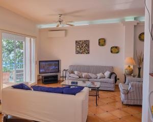 ein Wohnzimmer mit zwei Sofas und einem Fernseher in der Unterkunft MAGICA VISTA in Amalfi