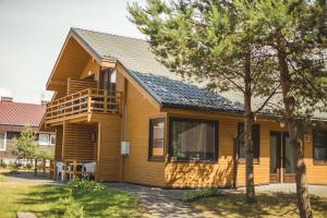 a wooden house with a porch and a deck at Vičiūnų poilsiavietė Šventojoje in Šventoji