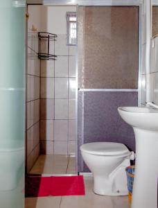uma casa de banho com um chuveiro, um WC e um lavatório. em Pousada Sucuri em Bonito