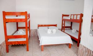 a room with two bunk beds with white sheets at Pousada Sucuri in Bonito
