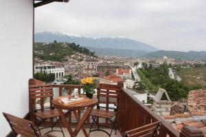 a balcony with a table and chairs and a view of a city at Guesthouse Arjan in Berat